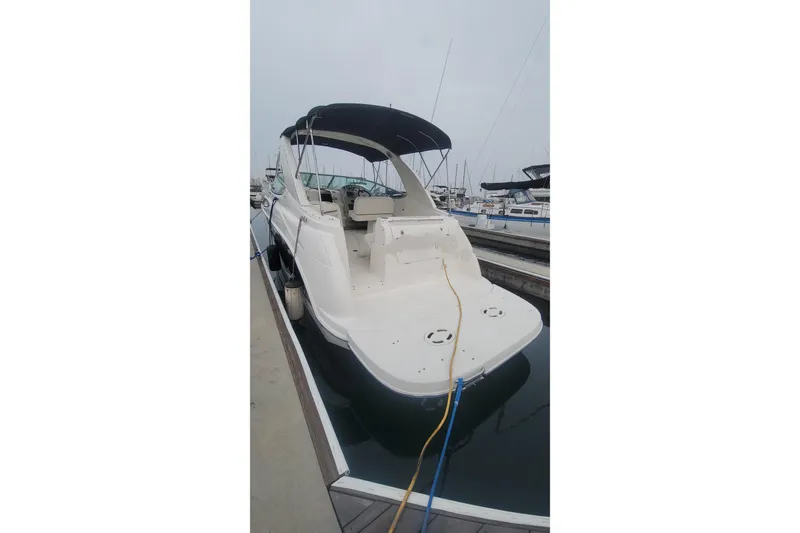 Slide: The Image of 2011 Bayliner 315 Cruiser docked at marina, rear view with canopy. - 4