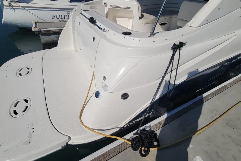 Slide: The Image of 2011 Bayliner 315 Cruiser docked, showing rear deck and mooring lines. - 5