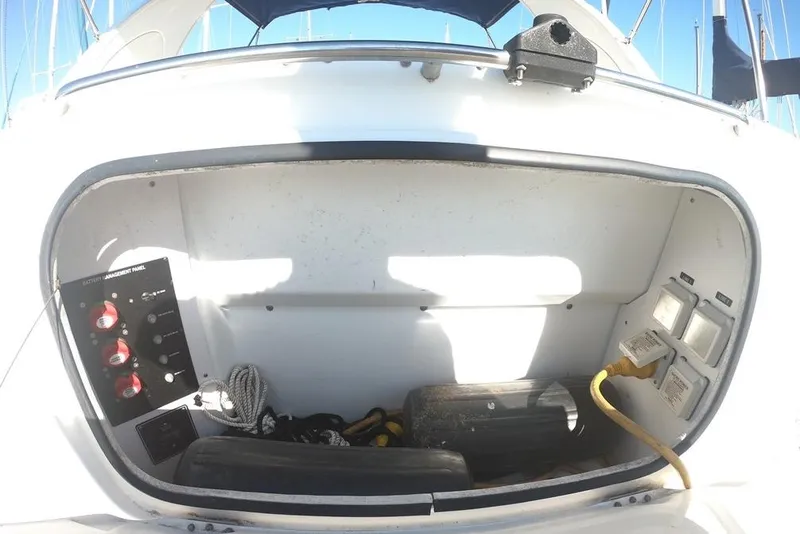 Slide: The Image of 2011 Bayliner 315 Cruiser storage compartment with battery management panel and electrical connections. - 6