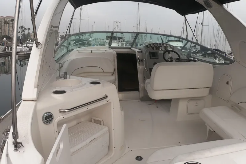 Slide: The Image of 2011 Bayliner 315 Cruiser interior with helm, seating, and marina view. - 7