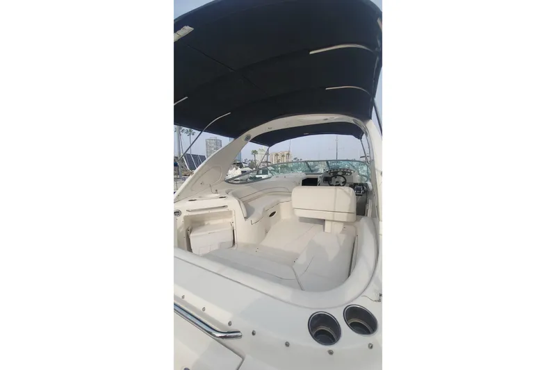 Slide: The Image of 2011 Bayliner 315 Cruiser interior with seating and helm, featuring a black canopy. - 8