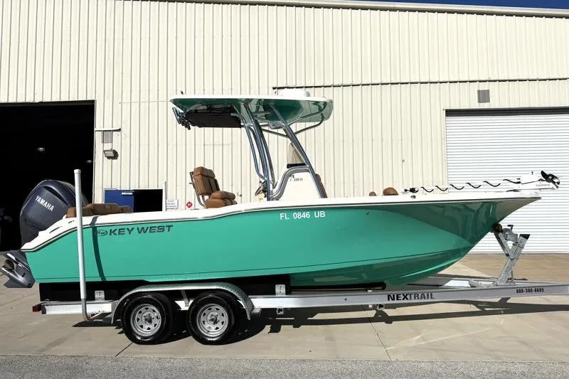 The Image of 2025 Key West 239 FS boat on trailer, parked outside a warehouse. - 0