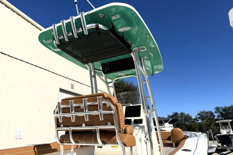 Slide: The Image of 2025 Key West 239 FS boat with teal canopy and tan seating, docked outdoors. - 16