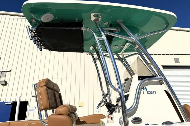 Slide: The Image of 2025 Key West 239 FS boat with T-top and seating, docked near a building. - 17