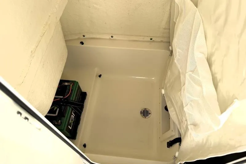 Slide: The Image of 2025 Key West 239 FS boat storage compartment with battery and drainage. - 29