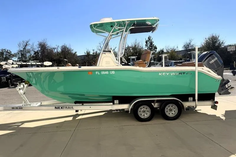 Slide: The Image of 2025 Key West 239 FS boat on trailer, vibrant teal color, parked outdoors. - 4