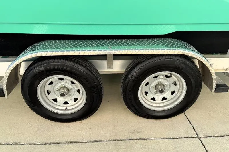 Slide: The Image of Trailer wheels of a 2025 Key West 239 FS boat on pavement. - 50
