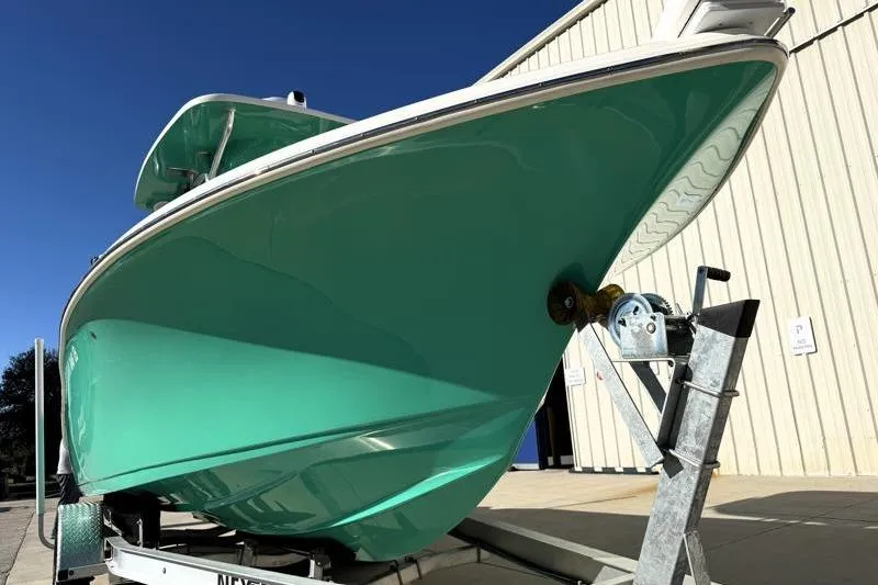 Slide: The Image of 2025 Key West 239 FS boat on trailer, vibrant teal hull, parked outdoors. - 6