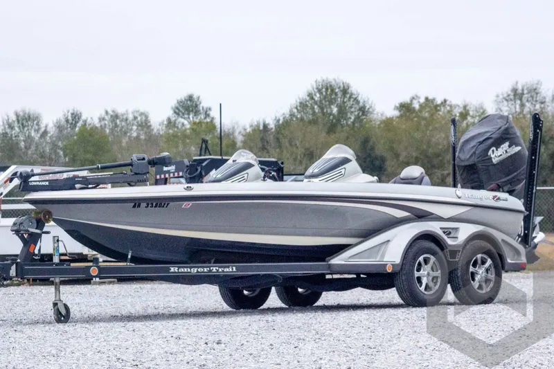 The Image of 2014 Ranger Z520 Comanche boat on trailer, parked outdoors with trees in background. - 1
