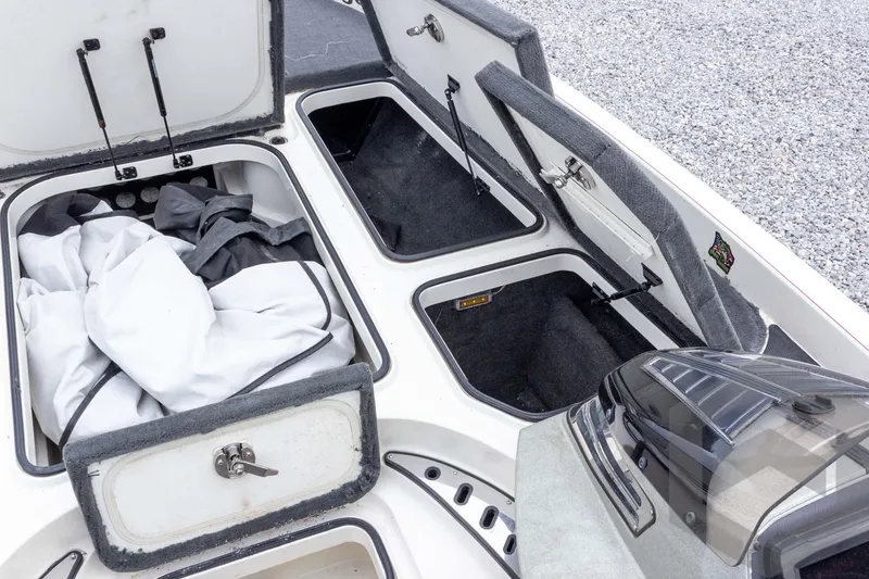 Slide: The Image of 2014 Ranger Z520 Comanche boat storage compartments with open hatches and gear inside. - 36