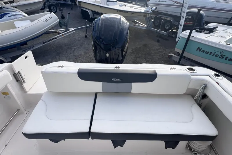 Slide: The Image of 2023 Robalo R222 Explorer boat interior with cushioned seating and outboard motor. - 15