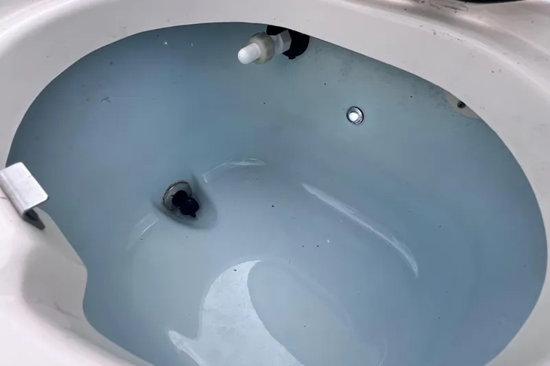 Slide: The Image of Livewell interior of 2023 Robalo R222 Explorer boat, showing drain and fittings. - 17