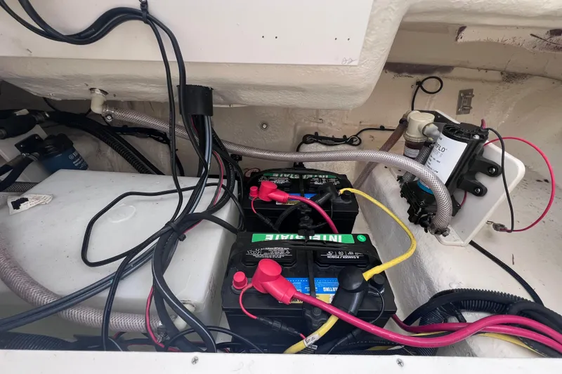 Slide: The Image of 2023 Robalo R222 Explorer boat battery compartment with wiring and components. - 19
