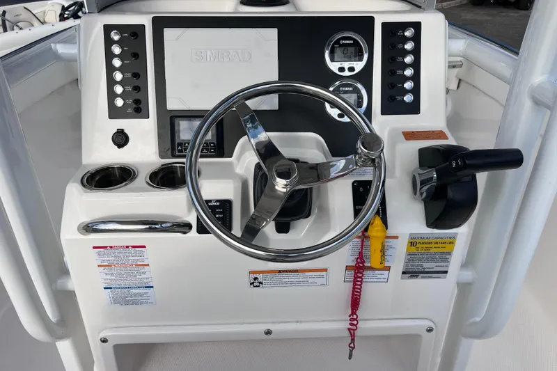 Slide: The Image of 2023 Robalo R222 Explorer boat dashboard with steering wheel and control panel. - 26