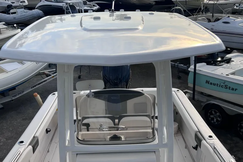 Slide: The Image of 2023 Robalo R222 Explorer boat with T-top, docked among other vessels. - 43