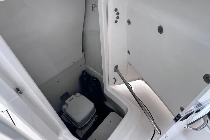 Slide: The Image of 2023 Robalo R222 Explorer boat interior storage compartment with portable toilet. - 46