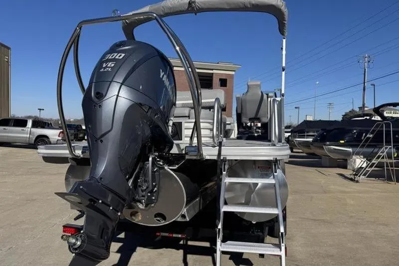 Slide: The Image of 2025 Bennington 26 MSB-ESP pontoon boat with Yamaha V6 engine, parked outdoors. - 26