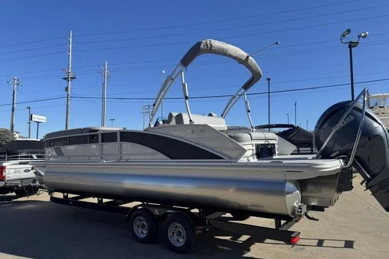 Slide: The Image of 2025 Bennington 26 MSB-ESP pontoon boat on trailer, parked outdoors. - 8