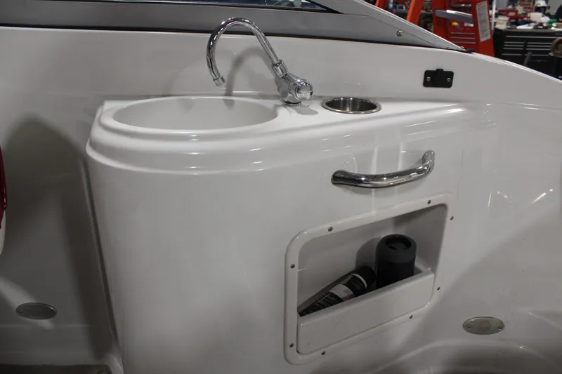 Slide: The Image of 2008 Crownline 220 EX boat interior sink with faucet and storage compartment. - 14