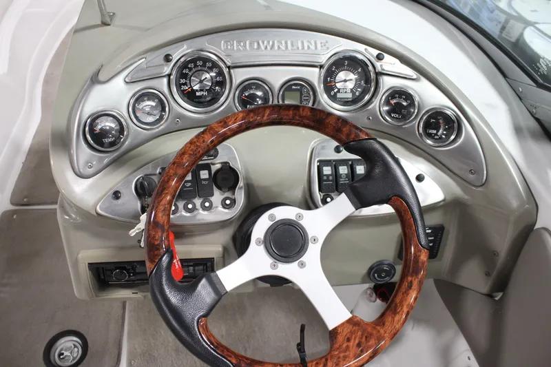 Slide: The Image of 2008 Crownline 220 EX boat dashboard with wood-accented steering wheel and instrument panel. - 16