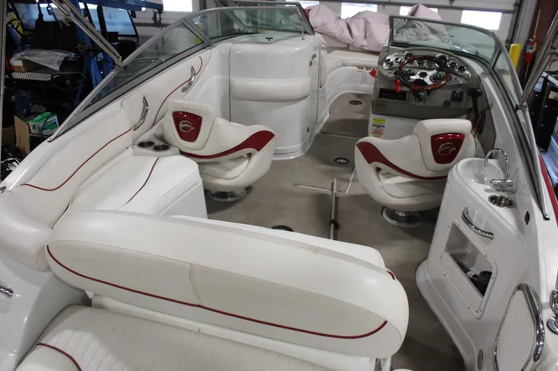 Slide: The Image of 2008 Crownline 220 EX boat interior with white and red seating, steering console, and cup holders. - 9