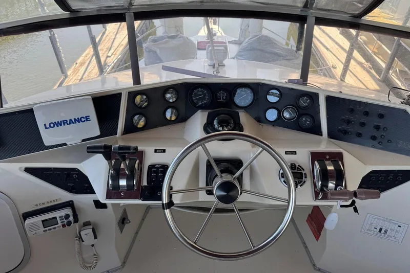 Slide: The Image of 1989 Sea Ray 300 Sedan Bridge helm with steering wheel and control panel. - 14