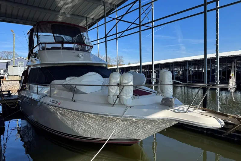 Slide: The Image of 1989 Sea Ray 300 Sedan Bridge docked under a marina canopy. - 2