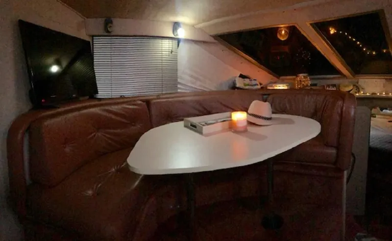 Slide: The Image of Interior of 1989 Sea Ray 300 Sedan Bridge with table and candle. - 21