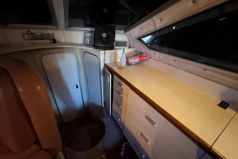Slide: The Image of Interior of 1989 Sea Ray 300 Sedan Bridge with cabinets and seating area. - 27
