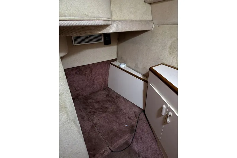 Slide: The Image of Interior cabin of 1989 Sea Ray 300 Sedan Bridge with carpet and storage. - 29