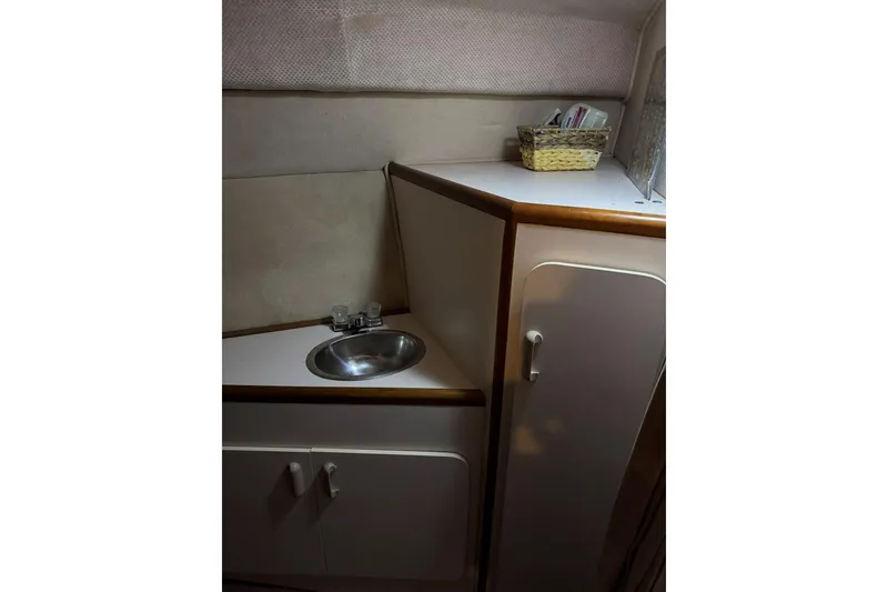 Slide: The Image of 1989 Sea Ray 300 Sedan Bridge interior with sink and storage cabinet. - 31