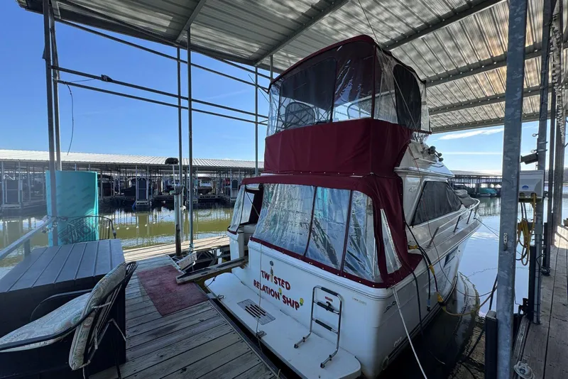 Slide: The Image of 1989 Sea Ray 300 Sedan Bridge docked under covered marina with red canopy. - 4
