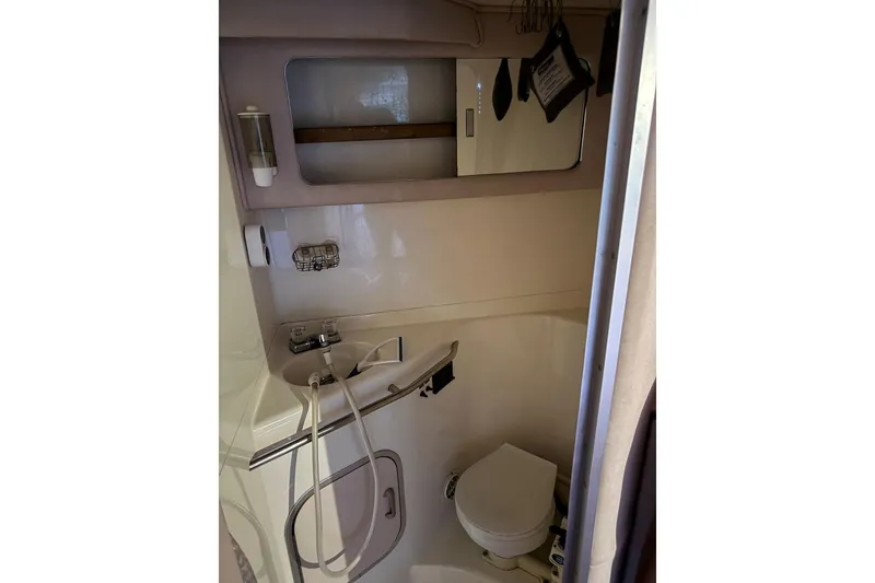 Slide: The Image of 1989 Sea Ray 300 Sedan Bridge bathroom with shower, toilet, and mirror. - 43