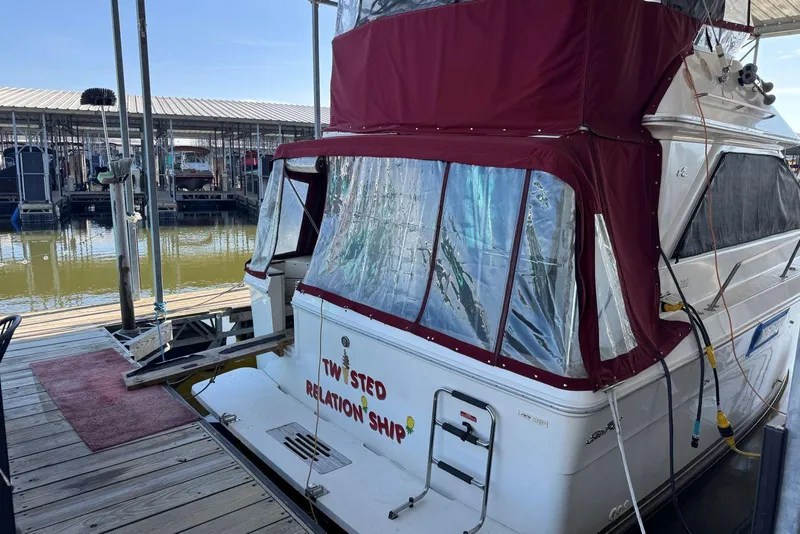 Slide: The Image of 1989 Sea Ray 300 Sedan Bridge docked with maroon canopy and humorous boat name. - 5