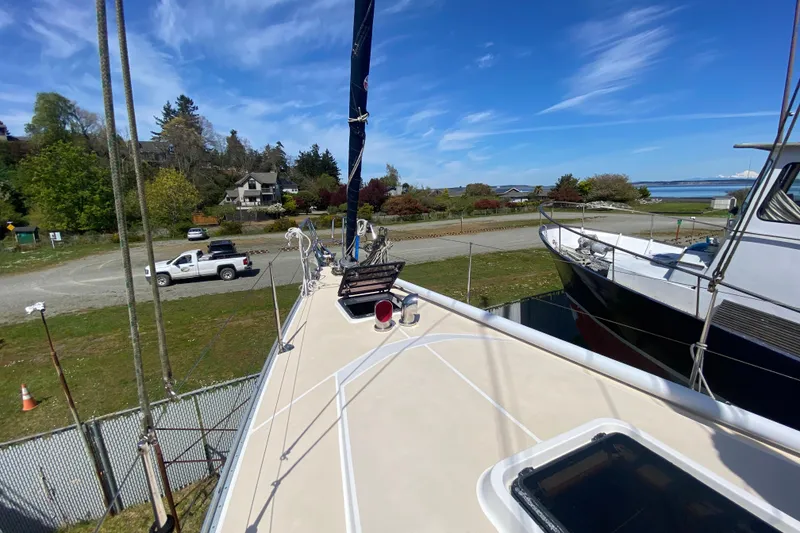 Slide: The Image of Sundeer 56 sailboat from 1995 docked near a scenic coastal area. - 23