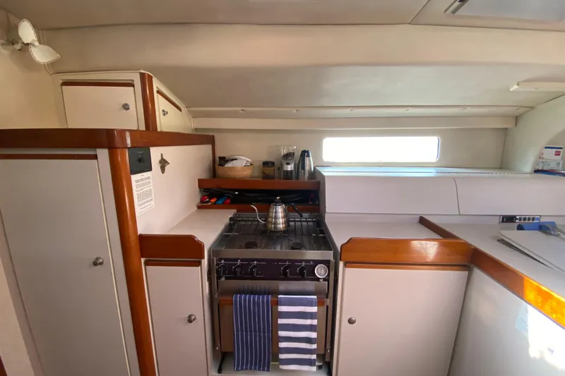 Slide: The Image of 1995 Sundeer 56 yacht kitchen with stove, cabinets, and window. - 3
