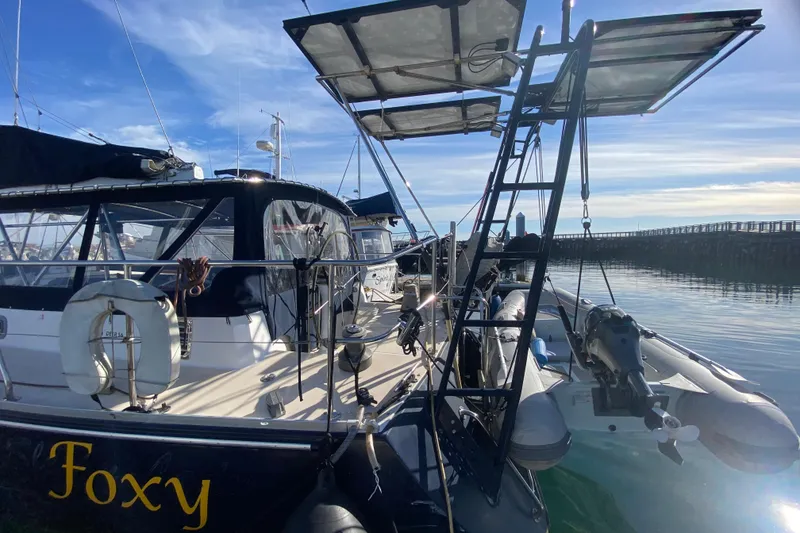 Slide: The Image of Sundeer 56 yacht from 1995 docked, featuring solar panels and a dinghy. - 32