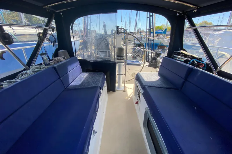 Slide: The Image of Interior view of a 1995 Sundeer 56 sailboat with blue seating and marina background. - 36