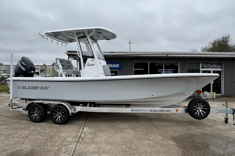 The Image of 2026 Blazer Bay 2440 boat on trailer, parked outside dealership. - 1