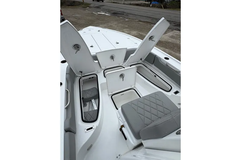 Slide: The Image of 2026 Blazer Bay 2440 boat interior with open storage compartments and cushioned seating. - 10