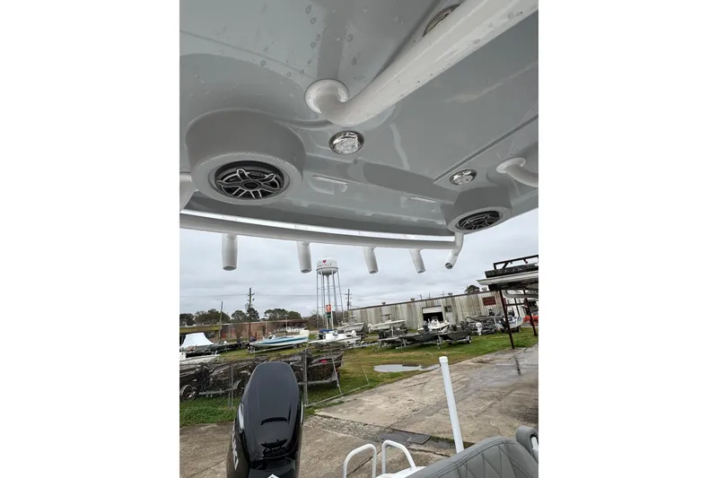 Slide: The Image of 2026 Blazer Bay 2440 boat with speakers and rod holders, docked outdoors. - 25