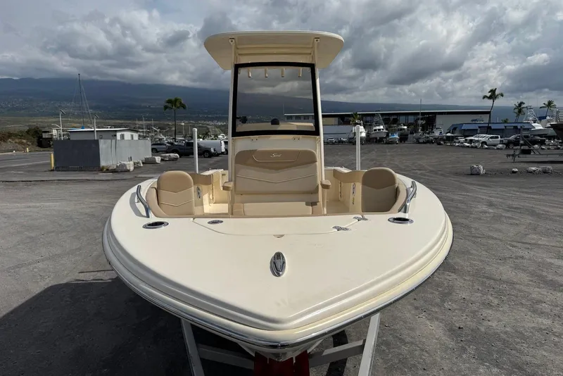 Slide: The Image of 2025 Scout 215 XSF boat on trailer at marina, cloudy sky backdrop. - 13