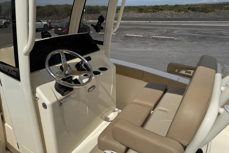 Slide: The Image of 2025 Scout 215 XSF boat interior with steering wheel and beige seating. - 17
