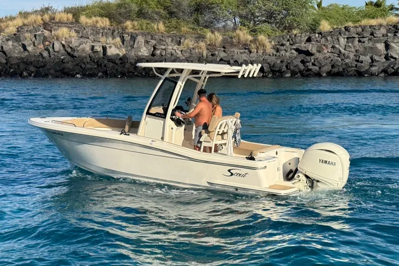 Slide: The Image of 2025 Scout 215 XSF boat cruising on blue water near rocky shoreline. - 3