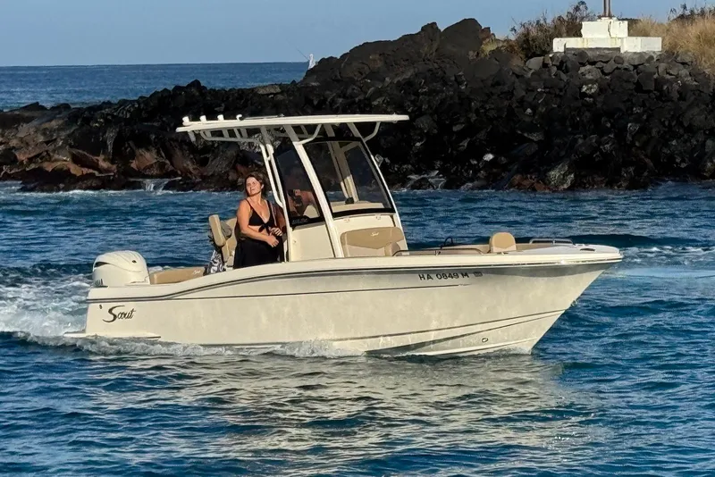 Slide: The Image of 2025 Scout 215 XSF boat cruising near rocky shoreline. - 4