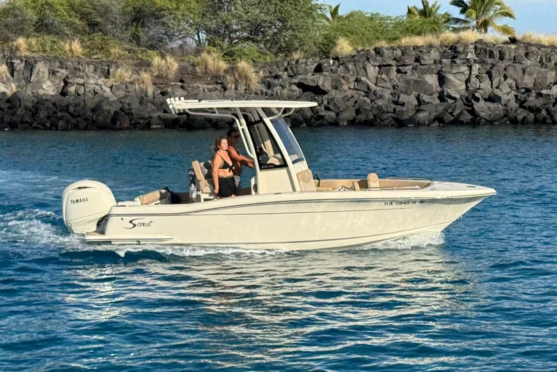Slide: The Image of 2025 Scout 215 XSF boat cruising on blue water near rocky shoreline. - 5