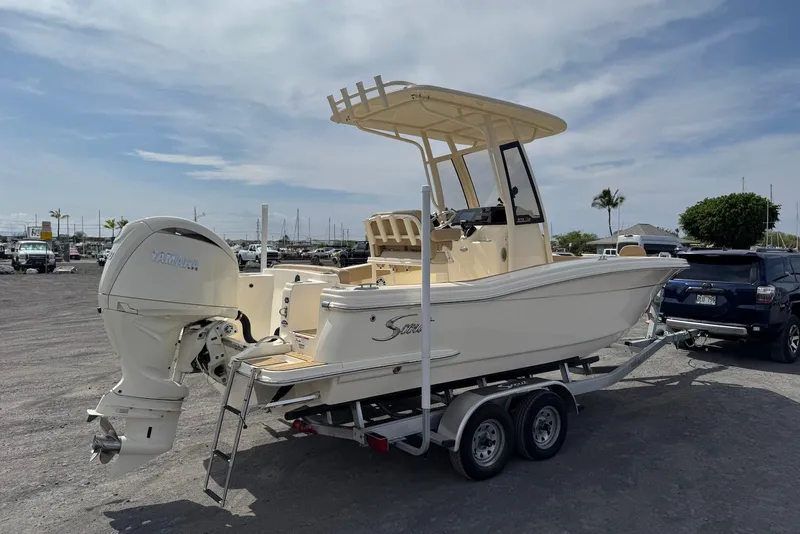 Slide: The Image of 2025 Scout 215 XSF boat on trailer with Yamaha outboard motor in parking lot. - 8