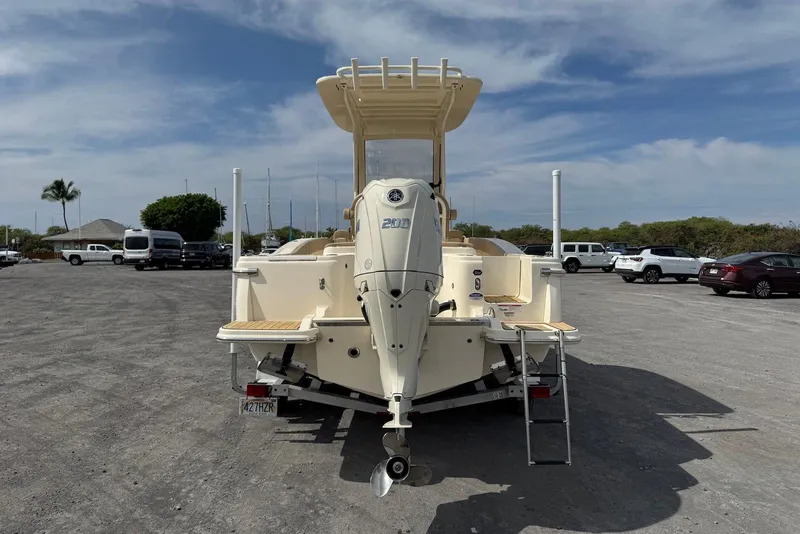 Slide: The Image of 2025 Scout 215 XSF boat on trailer, parked in a lot under a cloudy sky. - 9