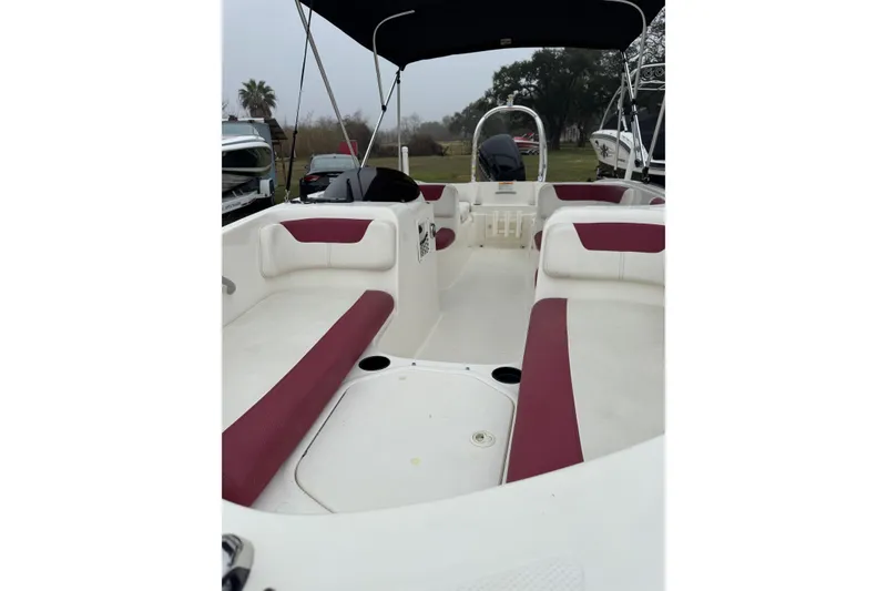 Slide: The Image of 2015 Bayliner Element 180 XL boat interior with red and white seating, under a canopy. - 3