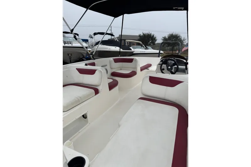 Slide: The Image of 2015 Bayliner Element 180 XL boat interior with red and white seating, under canopy. - 5